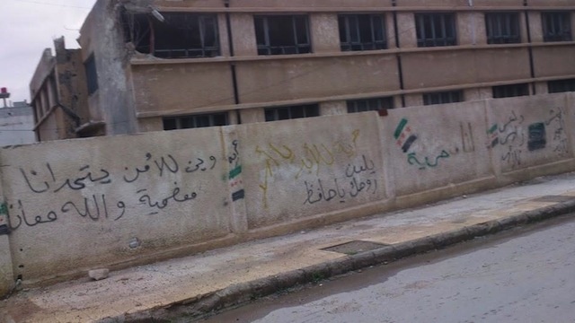 On a wall in Moadamiya: “Where is the [regime] security service to challange us? This is Moadamiya, and God is with us.”